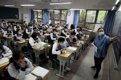 Guru dan sejumlah siswa SMA mengenakan masker dalam kegiatan belajar-mengajar pada hari pertama mereka kembali ke sekolah setelah wabah Covid-19, di Wuhan, Hubei, Cina, 6 Mei lalu.
