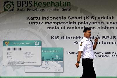 Petugas keamanan melintas di depan spanduk Badan Penyelenggara Jaminan Sosial (BPJS) Kesehatan di kantor pusat BPJS, Jakarta. TEMPO/Tony Hartawan