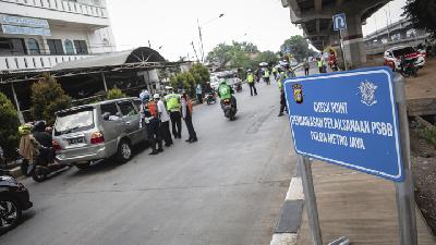 Petugas gabungan Polisi dan Dinas Perhubungan melakukan pengecekan pada  Check Point Pengawasan Pelaksanaan PSBB di Jalan Raya Kalimalang, Jakarta, J April 2020. TEMPO/M Taufan Rengganis
