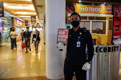 Petugas keamanan menunjukkan tanda imbauan wajib memakai masker kepada pengunjung di salah satu pusat perbelanjaan di Kota Semarang, Jawa Tengah, 18 Mei 2020. ANTARA/Aji Styawan