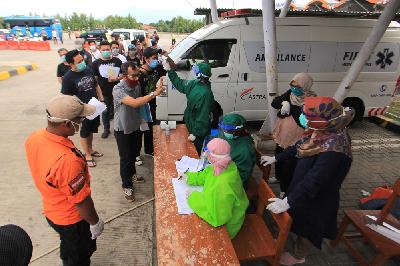 Petugas memeriksa kelengkapan dokumen dan penegcekan cek suhu badan penumpang bus di gerbang tol Cipali, Palimanan, Cirebon, Jawa Barat, 19 Mei 2020. ANTARA/Dedhez Anggara