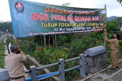Perangkat desa memasang spanduk himbauan untuk di rumah saja saat hari raya Idul Fitri di Gunung Gempol, Jumo, Temanggung, Jawa Tengah, 19 Mei 2020. ANTARA/Anis Efizudin