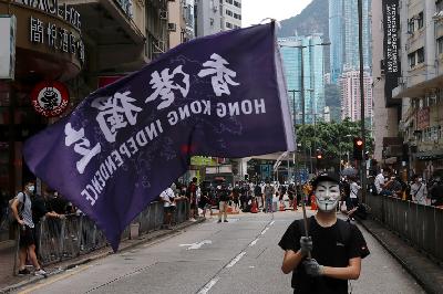 Seorang pendemo dengan mengenakan topeng memegang bendera yang mendukung kemerdekaan Hong Kong dalam aksi menentang rencana Beijing memberlakukan undang-undang keamanan nasional, 24 Mei 2020. REUTERS/Tyrone Siu/File Photo