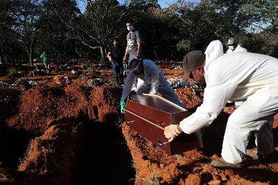 Petugas dengan pakaian pelindung menggali kuburan untuk Izolina de Sousa, 85 tahun yang meninggal karena Covid 19 di Pemakaman Vila Formosa, Sao Paulo, Brasil, 26 Mei 2020. REUTERS/Amanda Perobelli