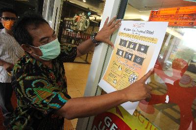 Pegawai menempelkan poster aturan new normal di BG Junction, Surabaya, Jawa Timur, 27 Mei 2020. ANTARA/Didik Suhartono