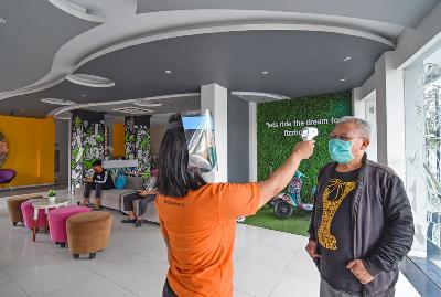 Petugas mengecek suhu tubuh pengunjung yang akan menginap di Fizz Hotel di Mataram, Lombok, Nusa Tenggara Barat, 21 April 2020. ANTARA/Ahmad Subaidi