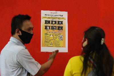 Pegawai swalayan Carrefour menunjukkan poster tentang Aturan New Normal Ritel kepada pengunjung di BG Junction, Surabaya, Jawa Timur, 27 Mei 2020. ANTARA/Didik Suhartono
