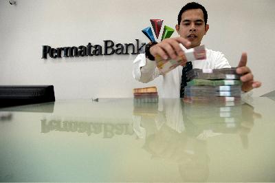 Petugas teller menghitung uang rupiah di kantor pusat Bank Permata, Jakarta. TEMPO/Tony Hartawan