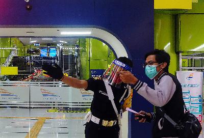 Petugas mengarahkan calon penumpang Kereta Api Luar Biasa di Stasiun Gambir, Jakarta 28 Mei 2020. TEMPO/Nurdiansah