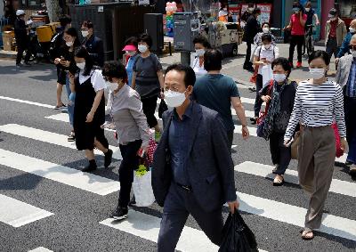 Warga mengenakan masker untuk menghindari penularan Covid-19 di Seoul, Korea Selatan, kemarin.