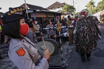 Polisi bertopeng Celuluk Corona dan polwan melakukan sosialisasi Covid-19 jelang new normal di Pasar Dharmasaba, Kabupaten Badung, Bali, 2 Juni 2020. FOTO: Johannes P. Christo