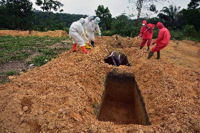 Sejumlah tenaga kesehatan dan penggali kubur mengenakan alat pelindung diri saat proses pemakaman jenazah dengan protokol kesehatan COVID-19 di Tempat Pemakaman Umum (TPU) Tengku Mahmud Palas, Kota Pekanbaru, Riau, 25 Mei 2020. ANTARA/FB Anggoro