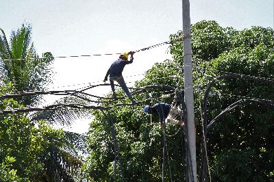Pekerja memasang kabel empetik milik PT PLN Persero di jalur aliran penghubung tiga kabupaten, Kendari, Sulawesi Tenggara, 10 Mei 2020. ANTARA/Jojon