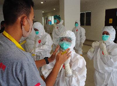Petugas memeriksa Alat Pelindung Diri (APD) Dokter dan tenaga medis sebelum memasuki ruang isolasi di Rumah Sakit Darurat (RSD) Covid-19 Wisma Atlet Jakarta, 15 Mei 2020. TEMPO/Nurdiansah