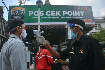 Petugas keamanan melakukan pengecekan suhu tubuh orang yang akan masuk ke kawasan Pondok Pesantren Tebuireng, Kabupaten Jombang, Jawa Timur, 16 Juni 2020. ANTARA/Syaiful Arif