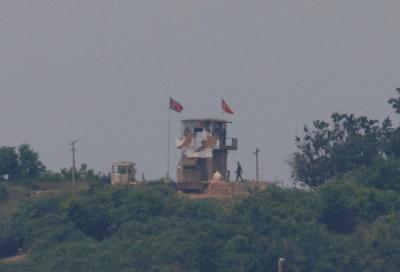 Seorang tentara Korea Utara terlihat di samping pos jaga di wilayah Korea Utara. Gambar ini diambil di dekat zona demiliterisasi yang memisahkan kedua Korea di Paju, Korea Selatan, 16 Juni 2020. REUTERS / Kim Hong-Ji