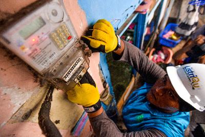 Petugas PLN melakukan pengecekan instalasi jaringan listrik di pemukiman padat penduduk di Tambora, Jakarta. Tempo/Tony Hartawan