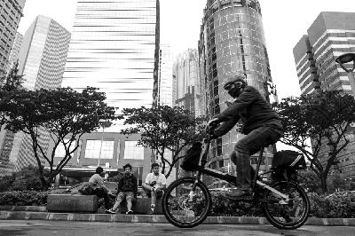 Karyawan melintas usai bekerja di jalan Sudirman, Jakarta, kemarin. TEMPO / Hilman Fathurrahman W