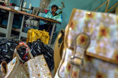 Pekerja menyelesaikan pembuatan kerajinan tangan tas dari bahan plastik daur ulang di  Pasar Minggu, Jakarta. TEMPO/Tony Hartawan