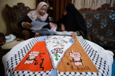 Pengungsi asal Palestina, Um Zeid  (kiri), membuat baju tradisional Palestina pesanan pelanggan di kamp pengungsi Al-Baqaa, Yordania, 16 Juni 2020. REUTERS/Muhammad Hamed