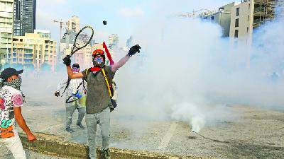 Demonstran melempar balik peluru gas air mata, selama demonstrasi menentang kebijakan ekonomi pemerintah dan menurunya pound libanon, di Beirut, Libanon, 6 Juni 2020. REUTERS/Aziz taher