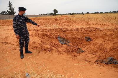 Tentara pasukan pemerintah Libya menunjuk kuburan massal di Kota Tarhuna, 11 Juni 2020. REUTERS/Ismail Zitouny