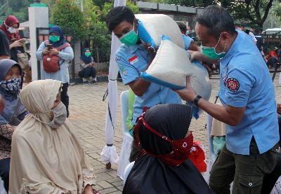 Petugas Kemensos memberikan beras kepada warga penerima paket sembako bantuan pemerintah tahap lima kepada warga di Rawa Buntu, Tangerang Selatan, Banten, 23 Juni 2020. ANTARA/Muhammad Iqbal