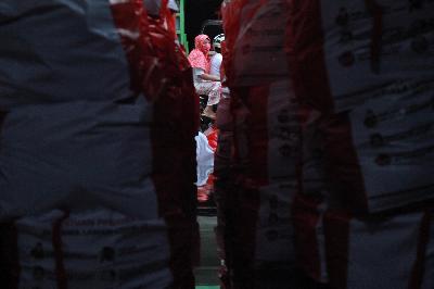 Warga melintas depan pos distribusi bantuan sosial dari Presiden RI di wilayah Rukun Warga (RW) 09, Kelurahan Pasar Minggu, Jakarta, 20 Mei 2020. TEMPO/Nita Dian