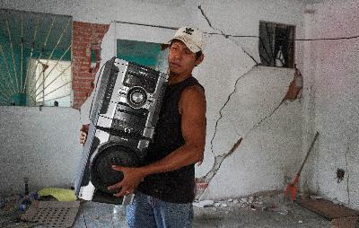 Warga menyelamatkan harta-benda usai gempa yang merusak kediamnnya di Huatulco, Oaxaca, Meksiko, 24 Juni 2020. REUTERS/Jose de Jesus Cortes