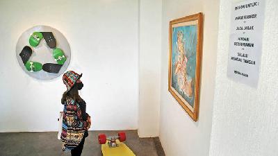 Pengunjung bermasker saat mengunjungi pameran Lucky Widiantara bertajuk Fun Follows Function Follows Fun, dengan latar belakang karya berjudul Reskatable, di Orbital, Bandung, Jawa Barat, 24 Juni 2020./foto-foto: TEMPO/Prima mulia