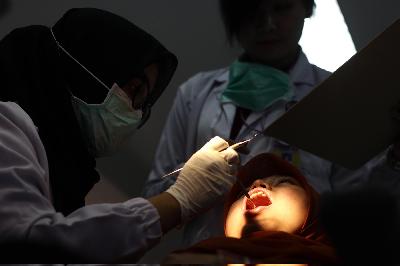 Dokter melakukan pemeriksaan gigi di Rumah Sakit Gigi dan Mulut (RSGM) Fakultas Kedokteran Gigi (FKG) Universitas Padjadjaran (Unpad), Bandung. Dok TEMPO/Aditya Herlambang Putra