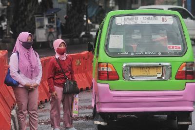 Warga saat menunggu kedatangan angkutan umum di Jalan Raya Pajajaran, Bogor, Jawa Barat, 14 April 2020.  TEMPO/Hilman Fathurrahman W