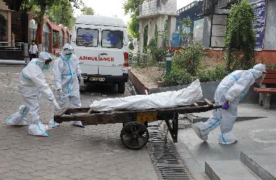 Petugas kesehatan membawa jenazah penderita Covid-19 untuk dikremasi di New Delhi, India, 28 Juni 2020. REUTERS/Adnan Abidi