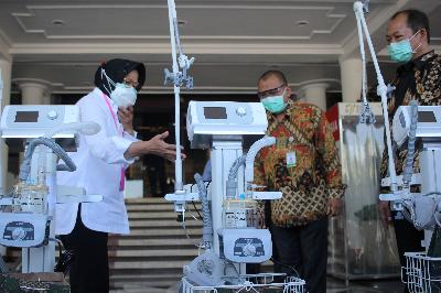 Wali Kota Surabaya Tri Rismaharini (kiri) memberikan peralatan medis kepada penerima bantuan di Balai Kota Surabaya, Jawa Timur, 30 Juni 2020. ANTARA/Didik Suhartono