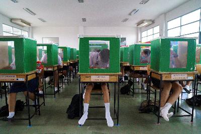 Siswa Sekolah Sam Khok di Provinsi Pathum Tani mengenakan masker dan penutup wajah tengah belajar dengan partisi plastik setelah pemerintah Thailand membuka sekolah secara nasional kemarin. REUTERS/Athit Perawongmetha