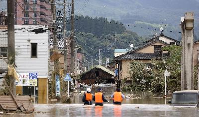 Petugas polisi mencari warga yang terjebak di daerah banjir di Hitoyoshi, Jepang, 4 Juli 2020. Kyodo/via REUTERS