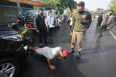 Petugas Satpol PP menghukum warga yang tidak mengenakan masker saat Operasi Patuh Masker di Jalan Nyamplungan, Surabaya, Jawa Timur, 6 Juli 2020. ANTARA/Didik Suhartono