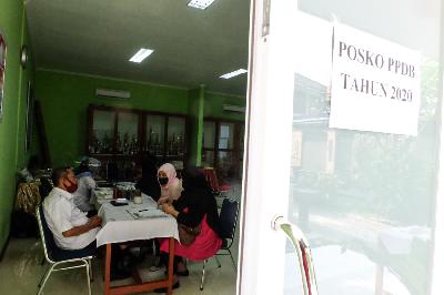 Orang tua siswa saat lapor diri pada petugas di posko Penerimaan Peserta Didik Baru (PPDB) di SMA Negeri 70 Jakarta, 8 Juli 2020.  TEMPO/Hilman Fathurrahman W