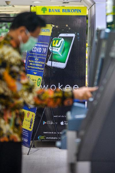 Nasabah melakukan transaksi pada mesin Anjungan Tunai Mandiri PT Bank Bukopin Tbk. (BBKP) di Jakarta, 18 Juni 2020. Tempo/Tony Hartawan