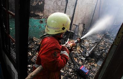 Petugas pemadam kebakaran berusaha memadamkan api yang membakar puluhan rumah di Kemayoran Gempol, Jakarta, 2018. TEMPO/Hilman Fathurrahman W