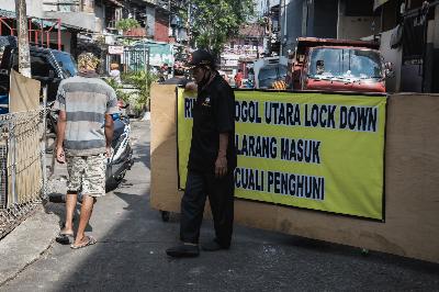 Petugas kemanan berjaga di akses keluar masuk pemukiman warga saat penerapan pembatasan sosial berskala lokal di RW 014 Grogol Utara, Kebayoran Lama, Jakarta Selatan, 7 Juli 2020.  TEMPO/M Taufan Rengganis