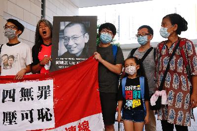 Aktivis pro-demokrasi melakukan aksi saat peringatan kematian Liu Xiaobo, di Hong Kong, Cina, 13 Juli 2020. REUTERS/Tyrone Siu