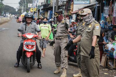 Petugas Satpol PP menindak warga yang melanggar aturan PSBB transisi karena tidak mengenakan masker di kawasan Pasar Minggu, Jakarta, 23 Juni 2020. TEMPO/M Taufan Rengganis