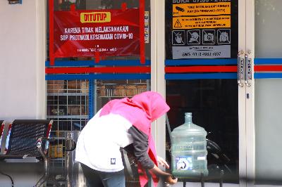 Warga mencuci tangan di depan toko yang ditutup di Banyuwangi, Jawa Timur, 13 Juli 2020. ANTARA/Budi Candra Setya