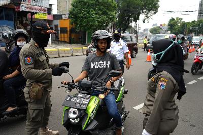 Petugas gabungan melakukan pemeriksaan terhadap pengendara yang tidak menggunakan masker di Jalan Proklamasi, Jakarta, 15 April 2020.  TEMPO/Muhammad Hidayat