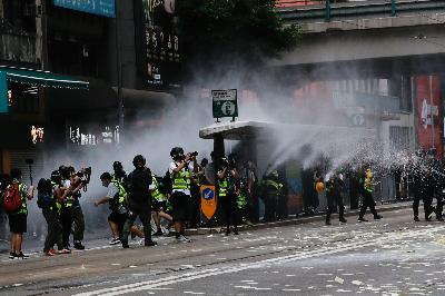 Polisi anti huru-hara menggunakan meriam air membubarkan pemrotes Undang-Undang Keamanan Nasional selama pawai peringatan penyerahan Hong Kong dari Inggris ke Cina, 1 Juli 2020. REUTERS / Tyrone Siu