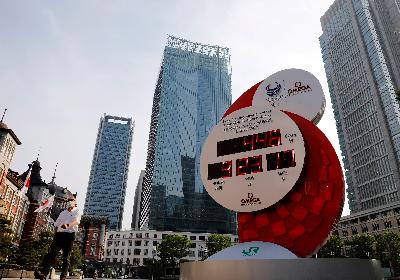 Warga menggunakan masker di depan penunjuk waktu hitung mundur Olimpade 2020 Tokyo 2020 di Tokyo, 4 Juni 2020. REUTERS/Kim Kyung-Hoon/File Photo