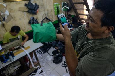 Pekerja tengah mengambil gambar melalui telepon pintar guna di pasarkan secara daring di lokasi pembuatan tas kamera di kawasan Manggarai, Jakarta, 16 Juli 2020. Tempo/Tony Hartawan