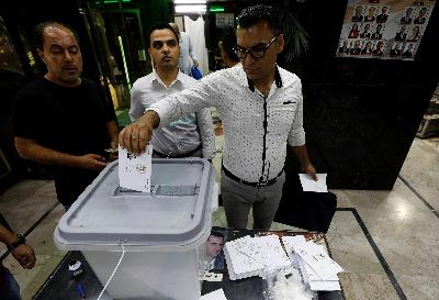 Warga memberikan suaranya ke dalam tempat pemungutan suara di Damaskus, Suriah, 19 Juli 2020. REUTERS/Omar Sanadiki