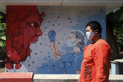 Warga melintas di dekat mural bergambar tenaga medis dan Virus Corona di kawasan Bantul, D.I Yogyakarta, 23 Juni 2020. ANTARA/Andreas Fitri Atmoko